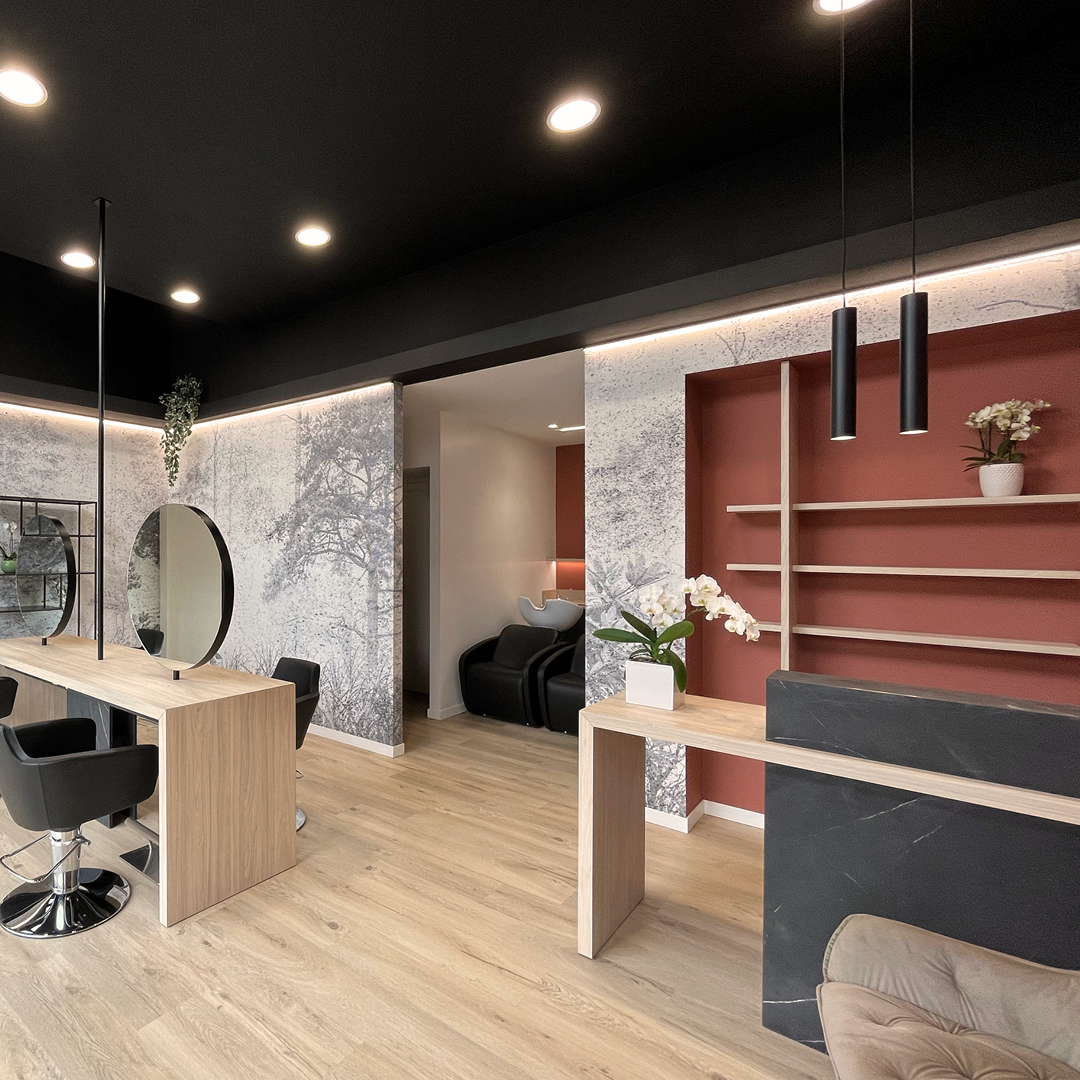immagine con visuale sia sull'area reception che stilistica, caratterizzata da una parete bianca con decorazioni floreali verdi  